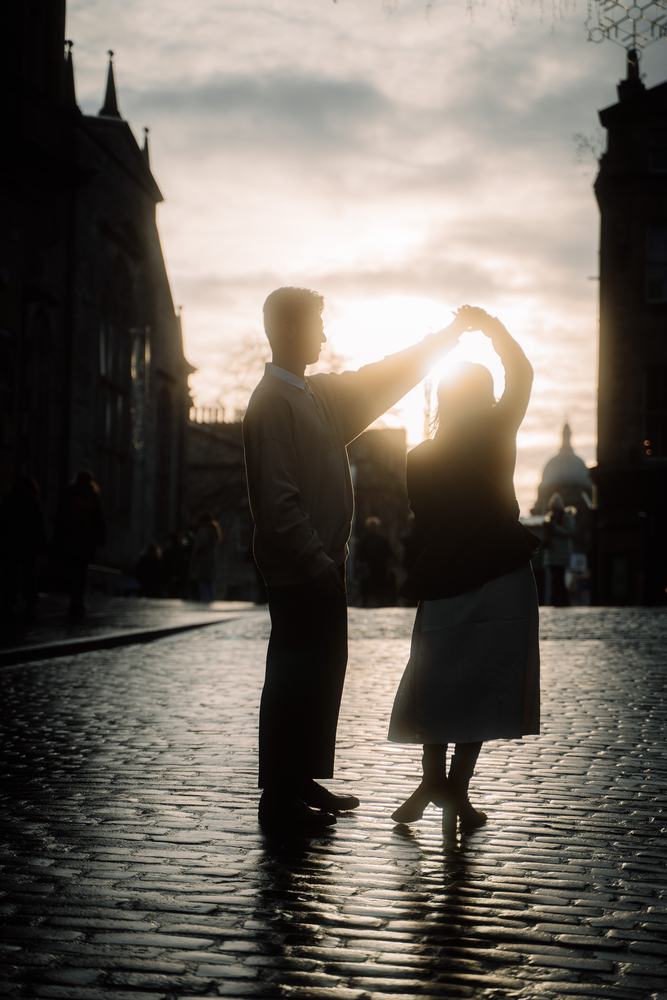 Couple dancing in silhouette on a cobbled Edinburgh street
