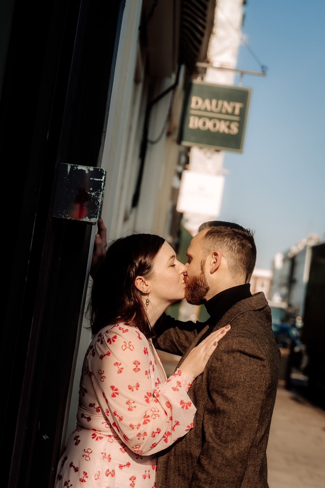 Couple kissing in a doorway beside the Daunt Books sign